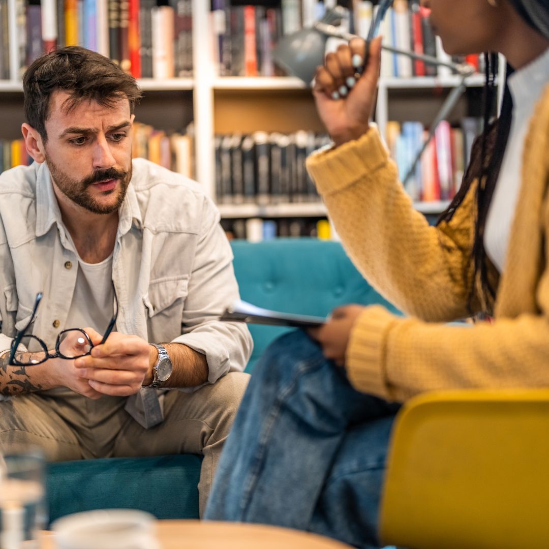 das Bild zeigt einen Mann, der von einem Therapeuten beraten wird