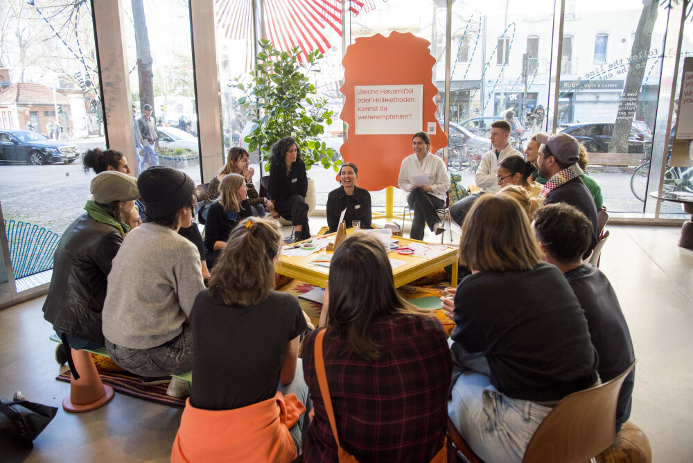Eine Gruppe von Menschen die im Kreis sitzen